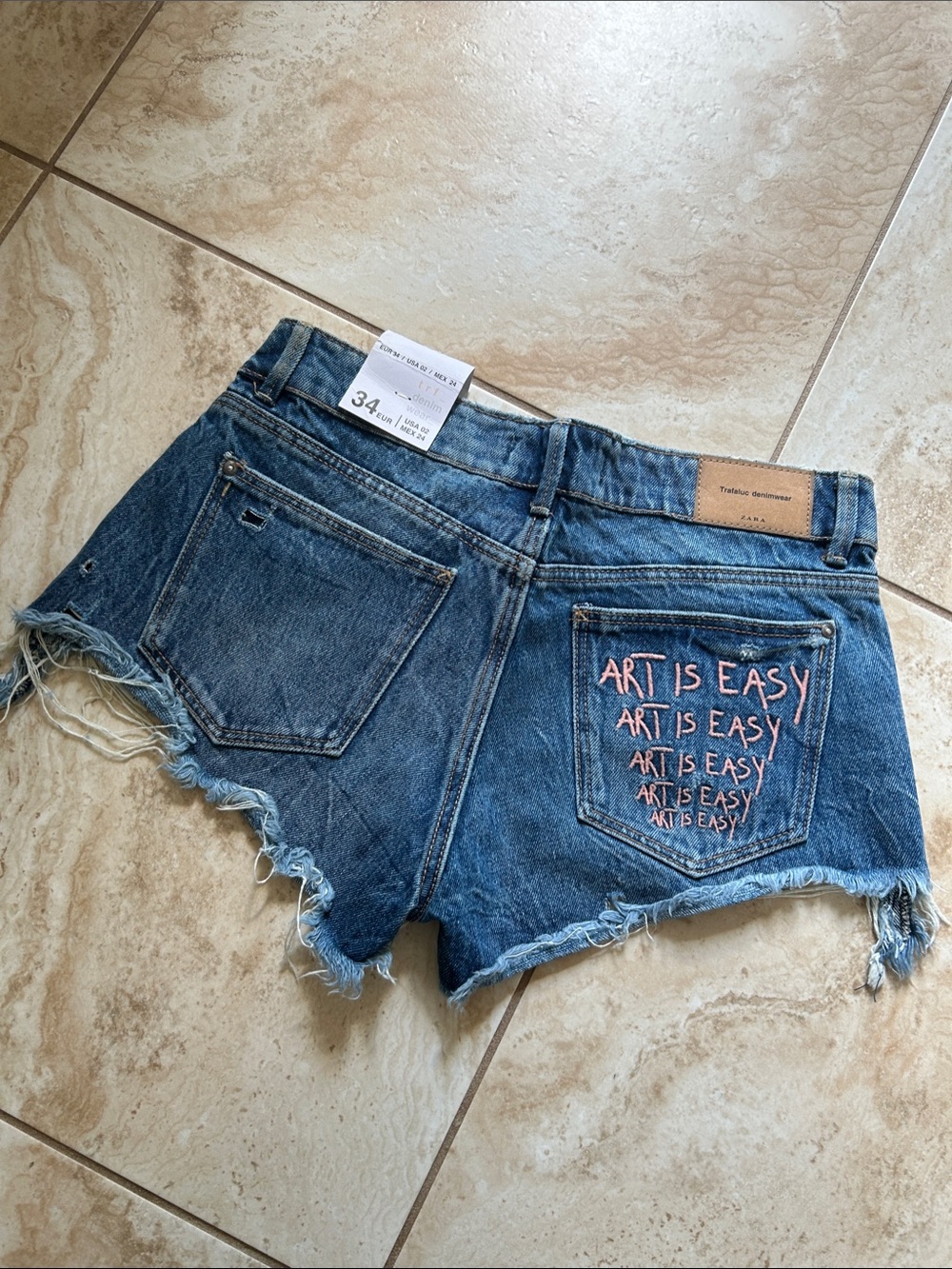 Zara Blue Denim Cutoff Shorts with Pink Embroidered 'Art Is Easy' Pocket